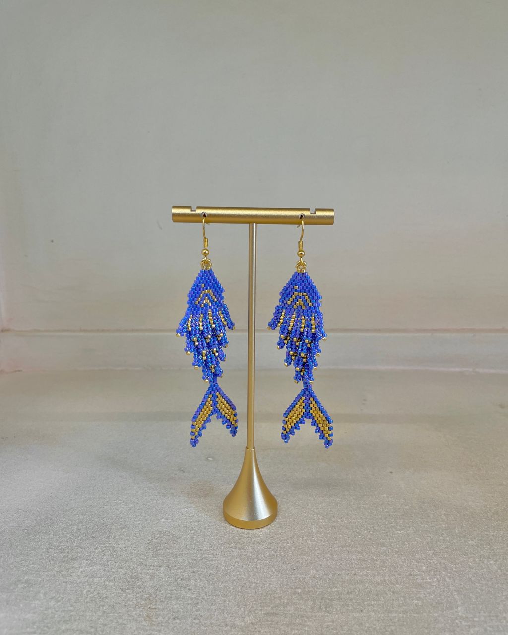 Aretes artesanales en miyuki en forma de pez, colgantes, color azul.