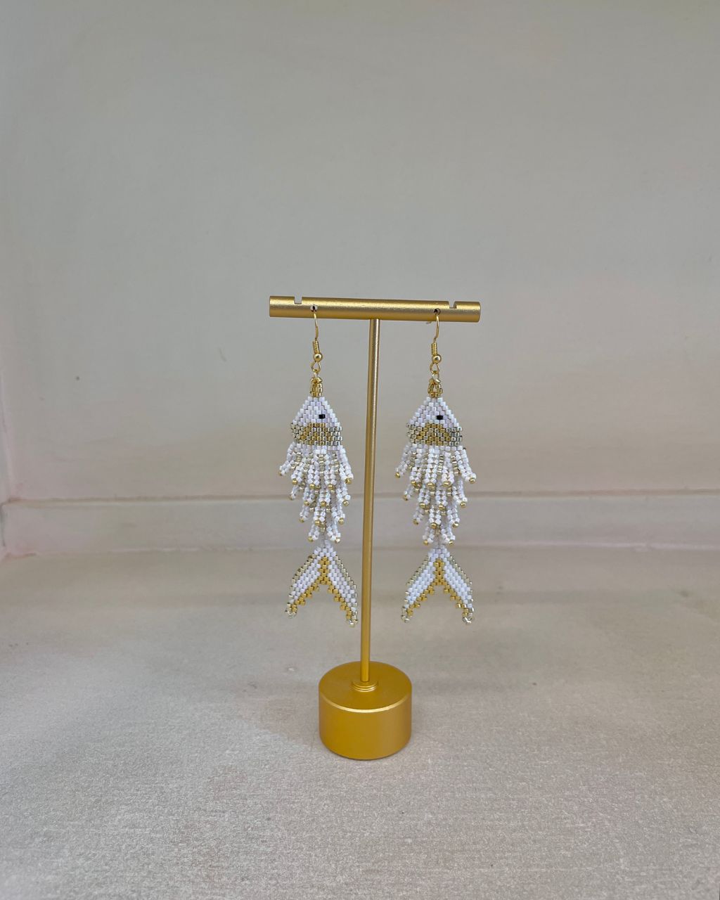 Aretes artesanales en miyuki en forma de pez, colgantes, color blanco.