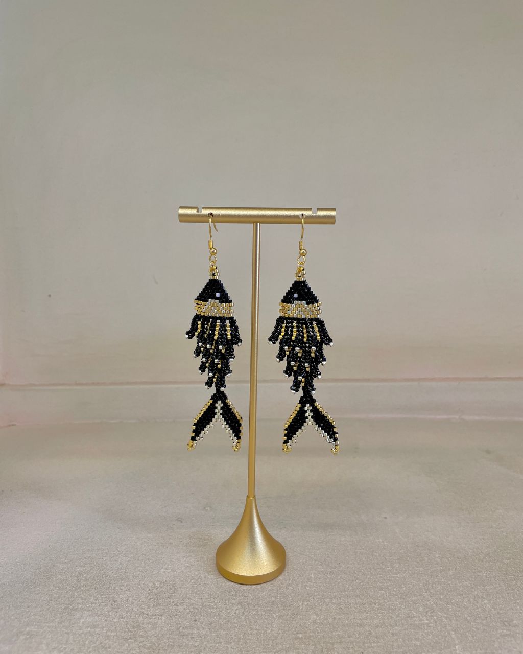 Aretes artesanales en miyuki en forma de pez, colgantes, color negro.