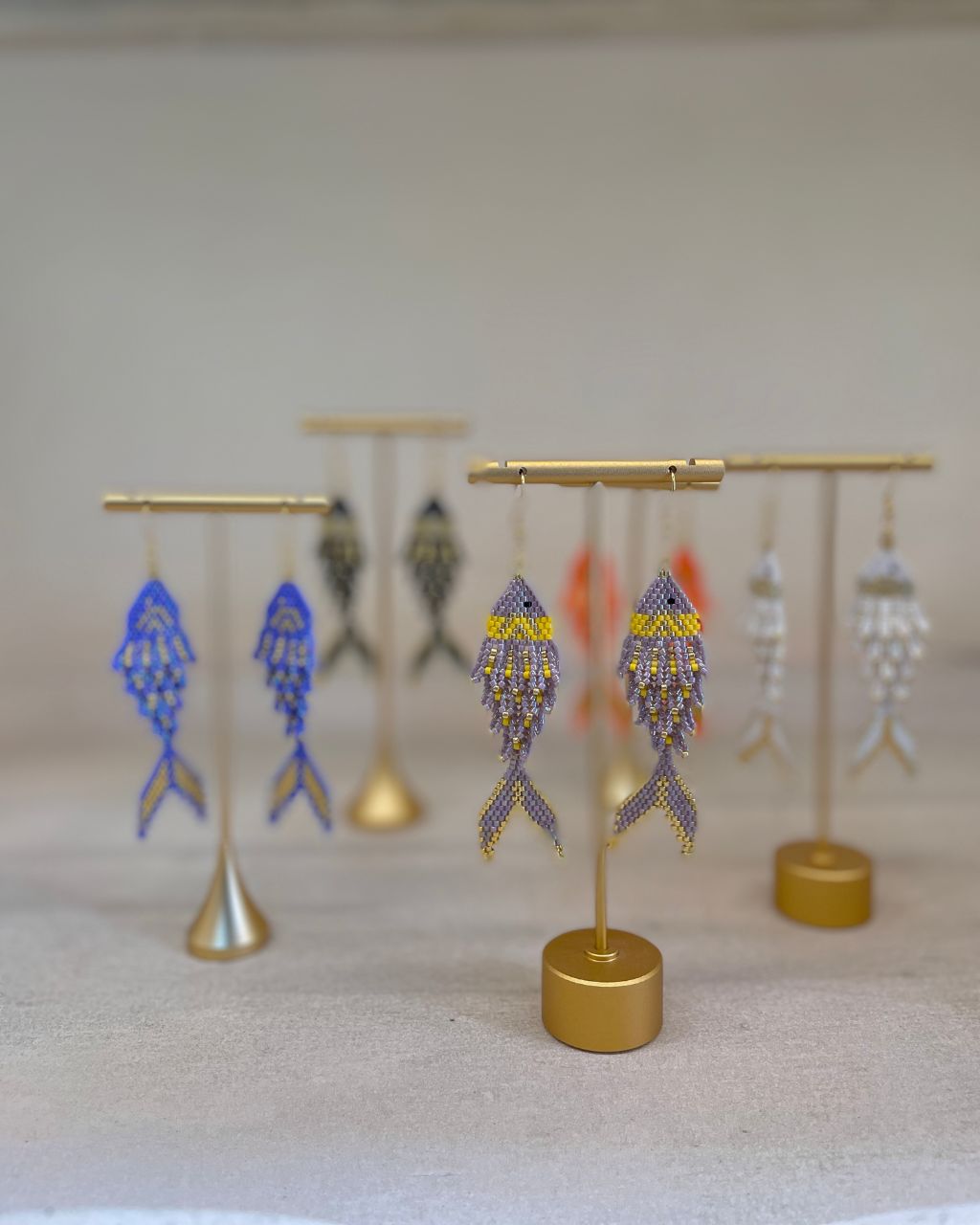 Aretes artesanales en miyuki en forma de pez, colgantes, de varios colores.