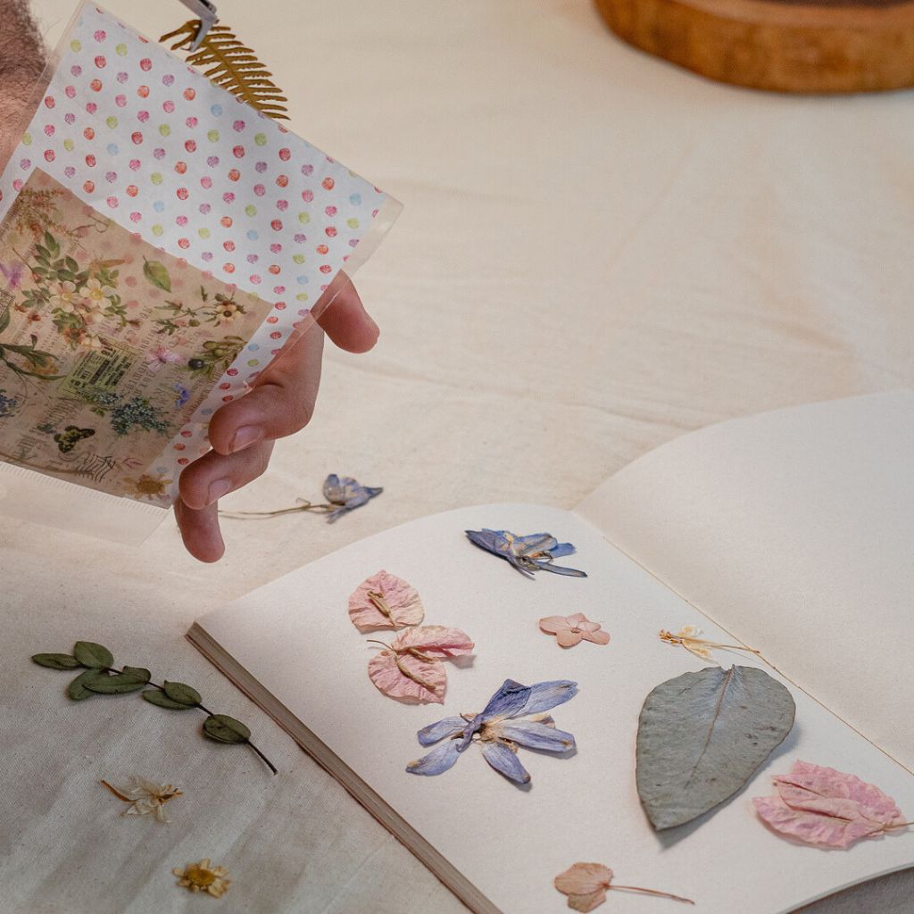 Flores naturales prensadas de Colombia, con papel de recortes y una pegatina decorativa.