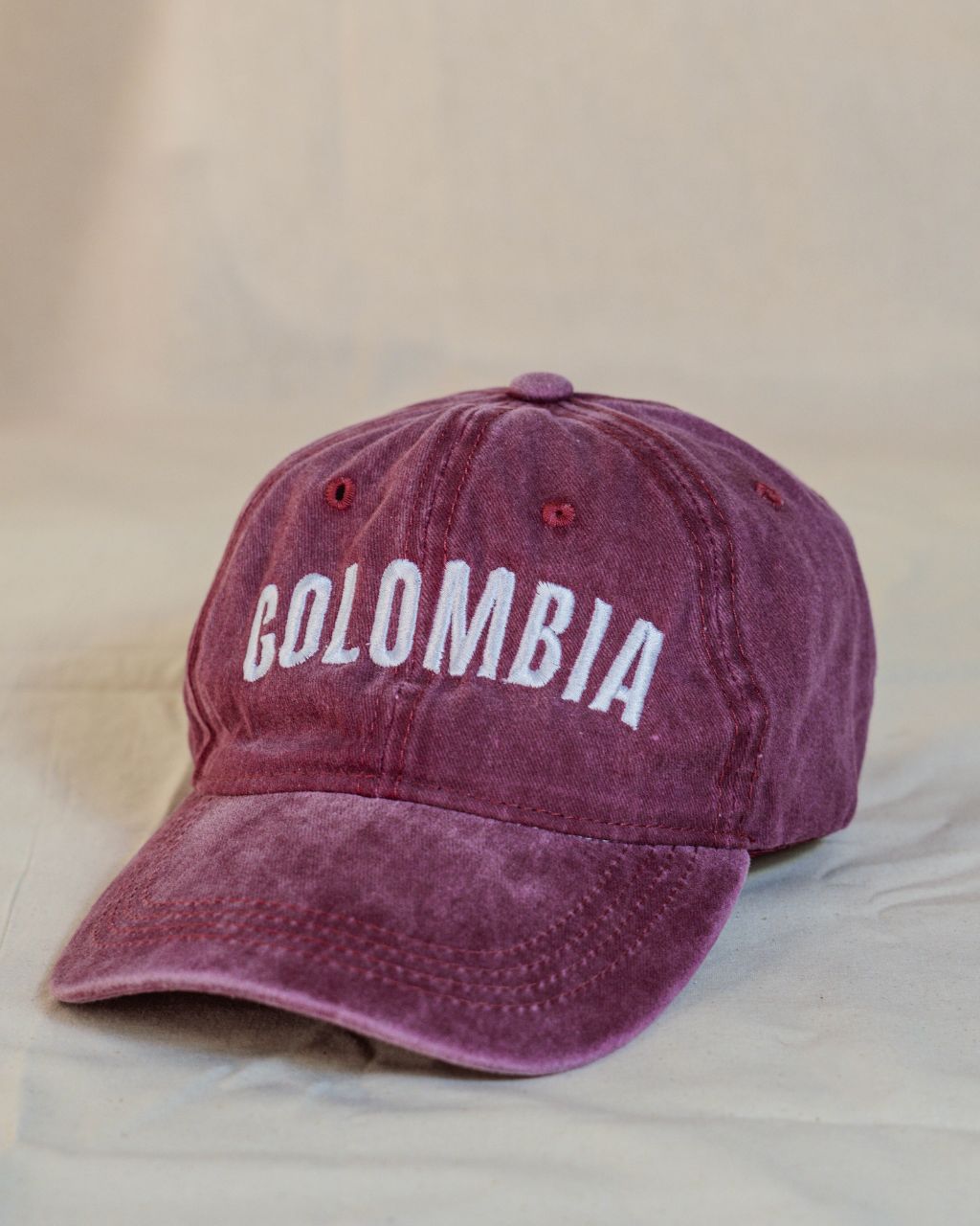 Gorra roja con letras blancas en mayúscula que contiene la palabra Colombia.