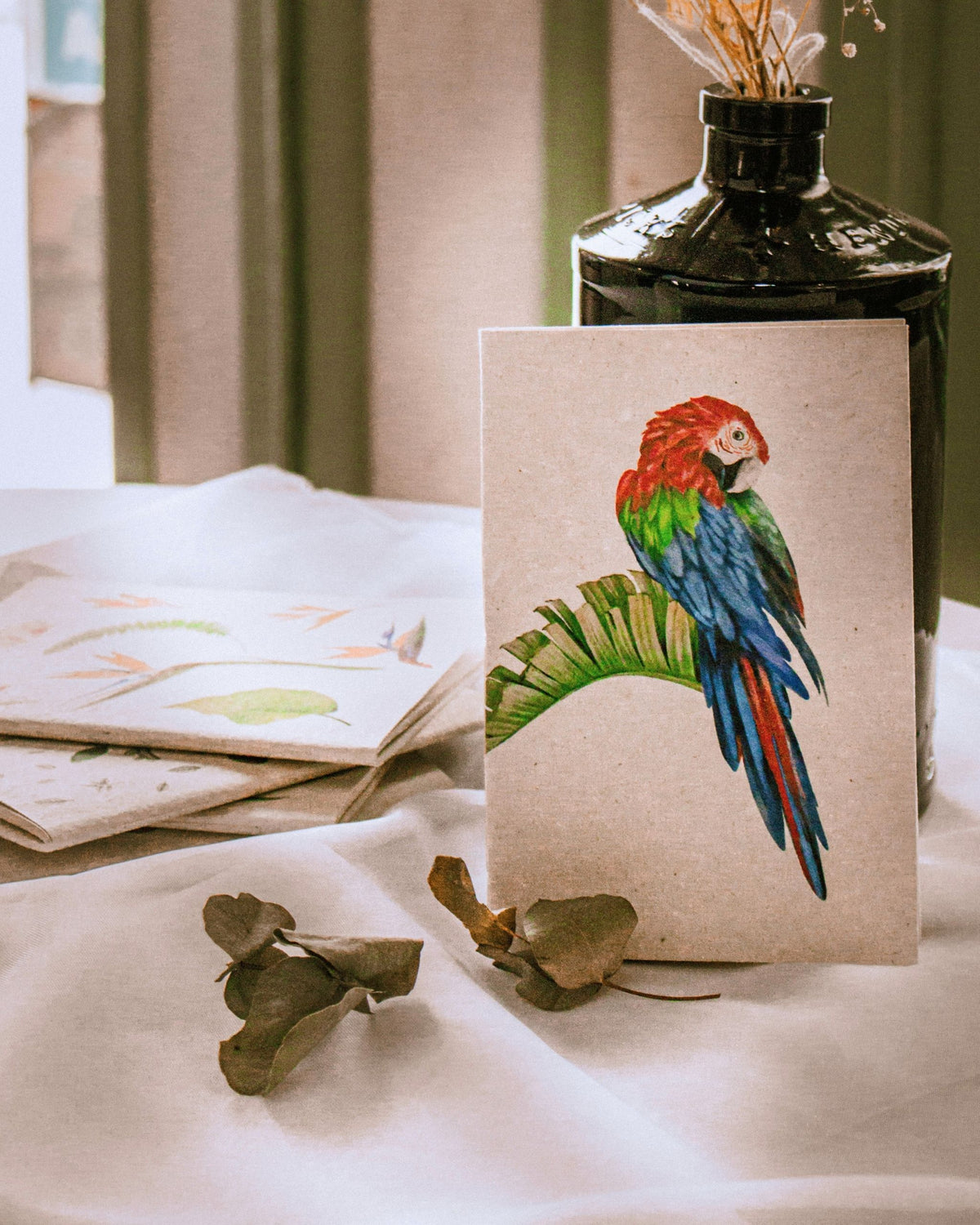 Cuadernillo ecológico con motivo de Guacamayo, Ave icónica de Colombia, fondo crudo y detalles coloridos.