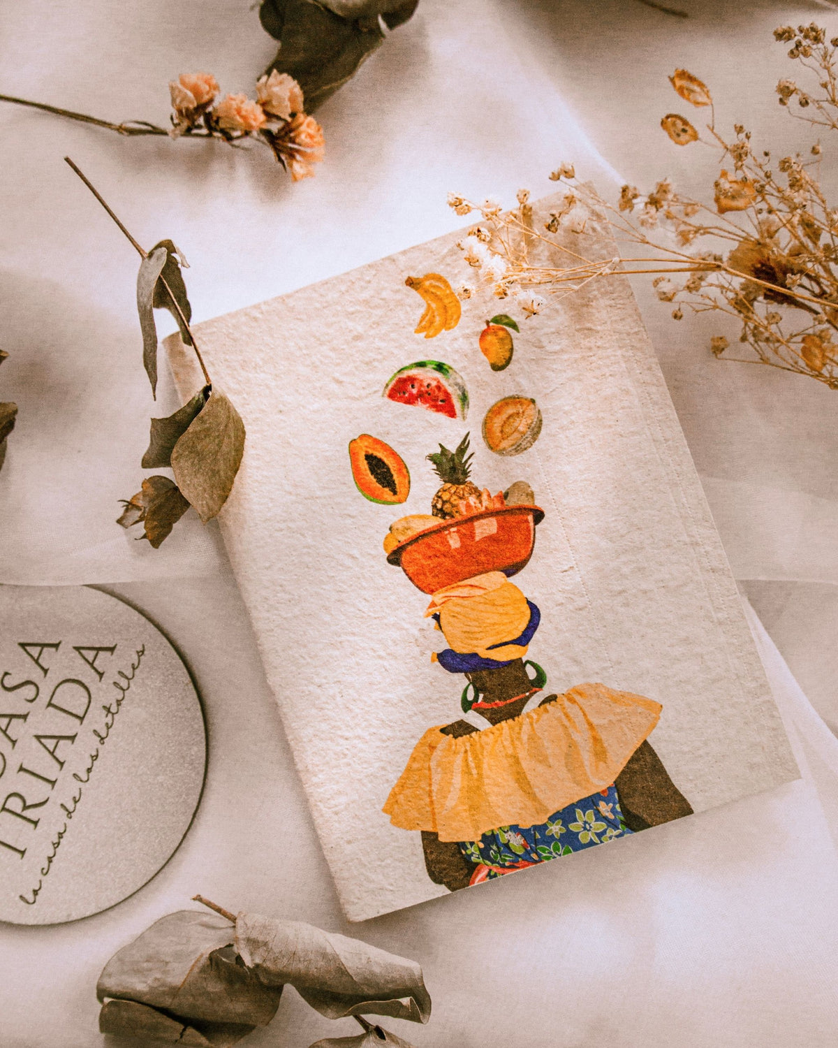 Cuadernillo ecológico con motivo de palangana de frutas y palenquera fondo crudo con detalles coloridos.