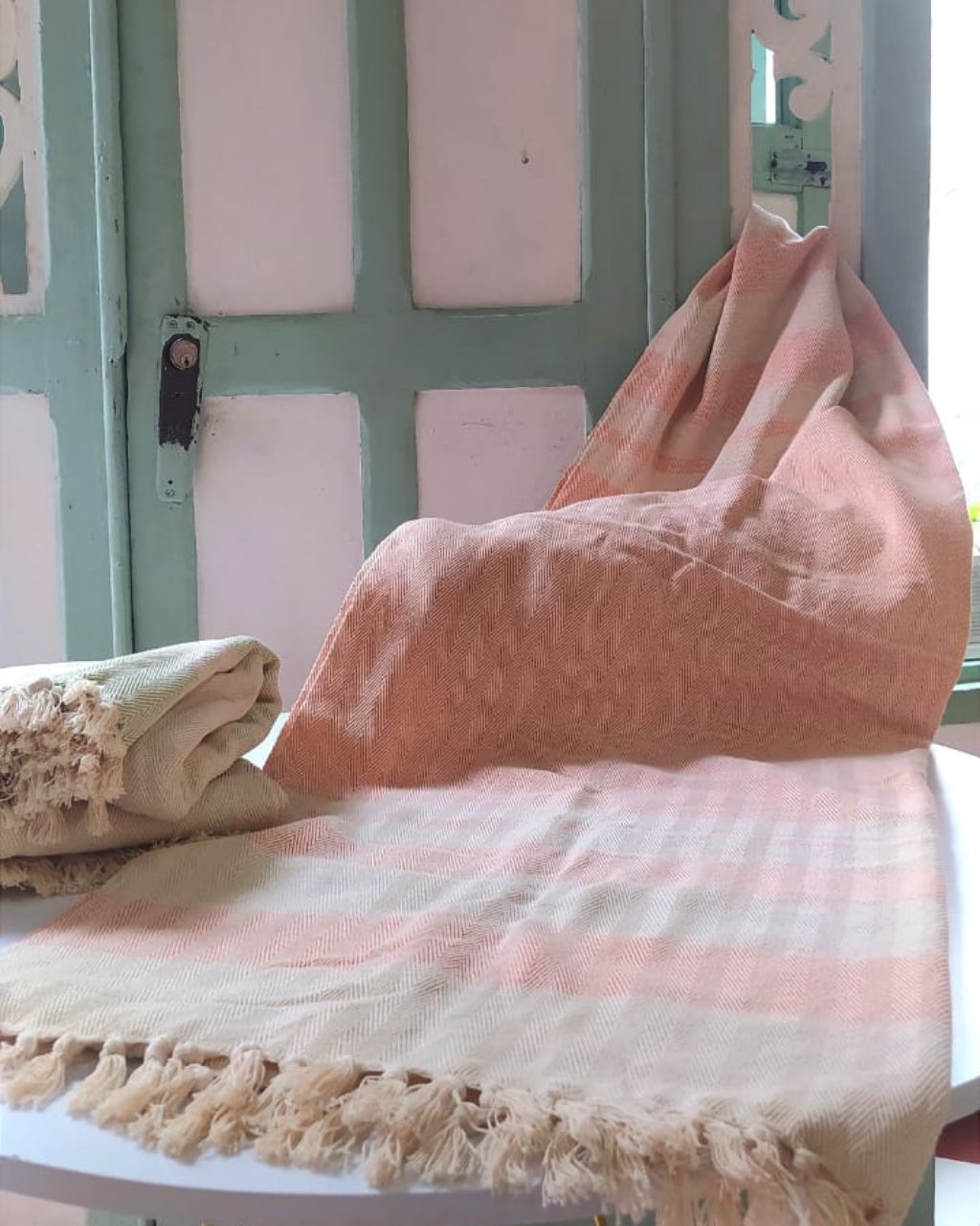 Mantas de algodón hechos por artesanos de la Sierra Nevada de Santa Marta, en color natural y naranja.