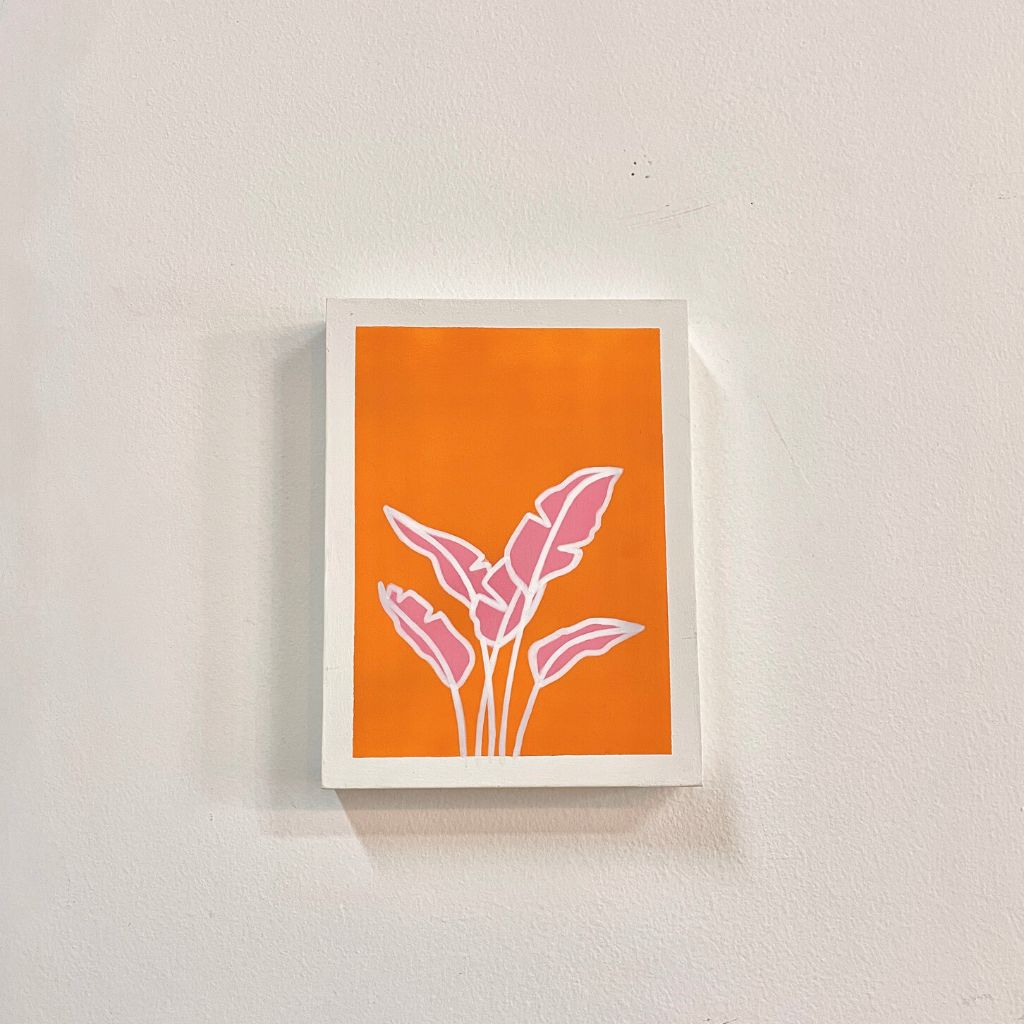Arte con la técnica de línea clara que ilustra mini hoja de plátano rosada sobre color naranja, tamaño 17.5 x 22.5 cm.